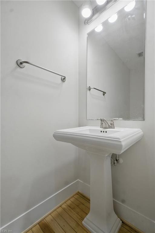 bathroom featuring baseboards, visible vents, and wood finished floors