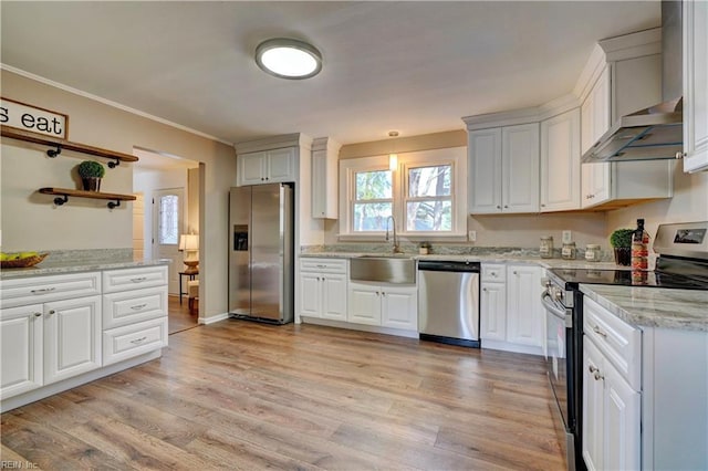 kitchen with crown molding, open shelves, appliances with stainless steel finishes, light stone countertops, and a sink