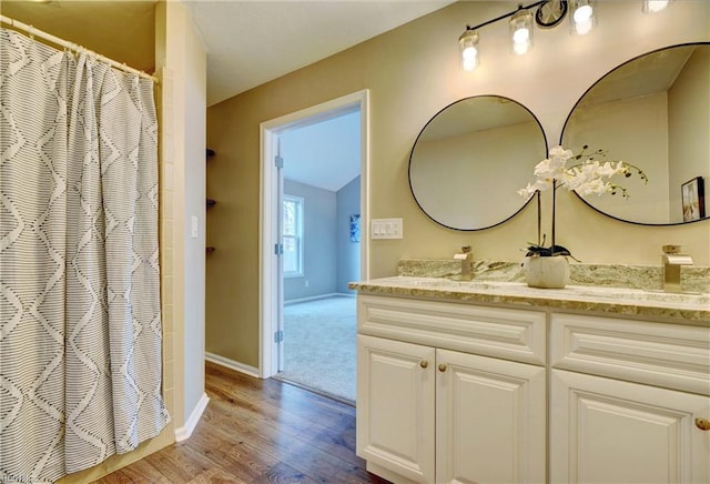 full bath with vanity, baseboards, wood finished floors, and curtained shower