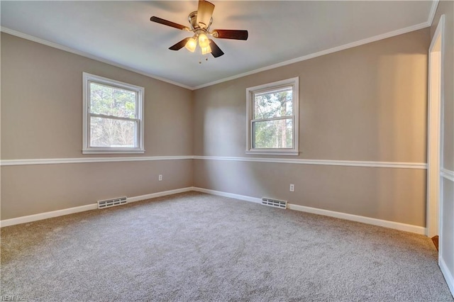 spare room with visible vents, ornamental molding, baseboards, and a ceiling fan