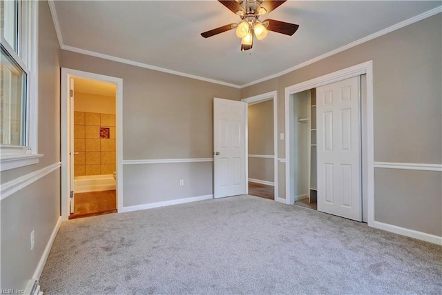 unfurnished bedroom featuring crown molding, ceiling fan, carpet floors, baseboards, and a closet