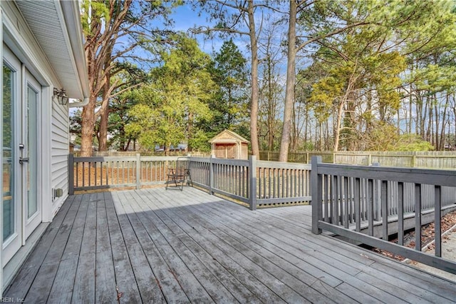 wooden deck featuring a fenced backyard and an outdoor structure