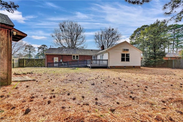 back of house featuring crawl space, a chimney, a deck, brick siding, and a fenced backyard