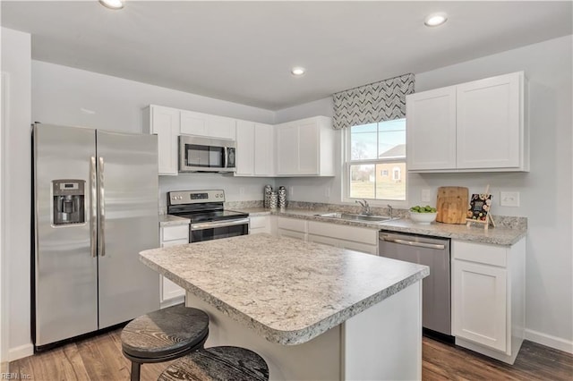 kitchen featuring a sink, appliances with stainless steel finishes, white cabinets, and dark wood finished floors