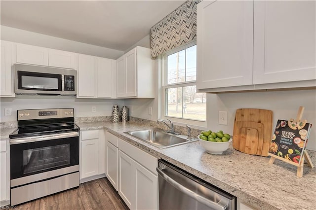 kitchen featuring a sink, appliances with stainless steel finishes, white cabinets, and light countertops