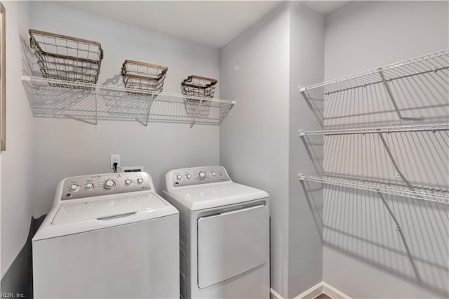laundry room with laundry area, baseboards, and washer and dryer