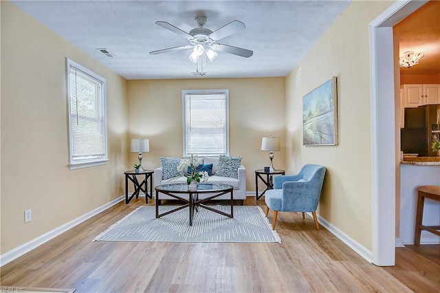 living area featuring baseboards, plenty of natural light, light wood finished floors, and visible vents