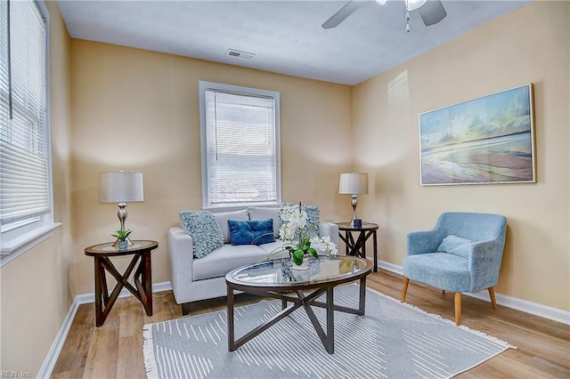 sitting room featuring baseboards, a ceiling fan, wood finished floors, and visible vents