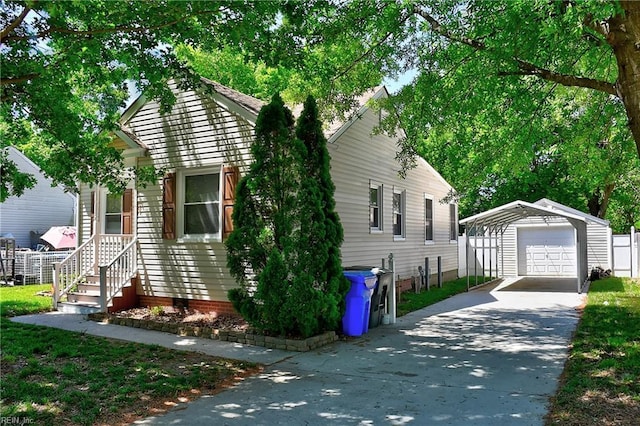 view of front of house featuring a garage, an outbuilding, and driveway