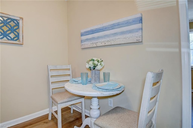 dining space featuring baseboards and wood finished floors