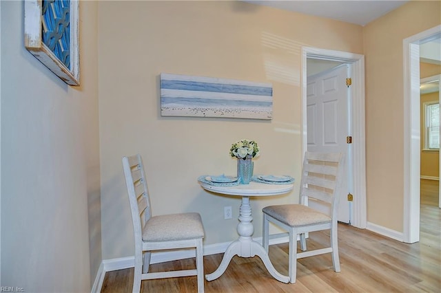 dining area with baseboards and wood finished floors