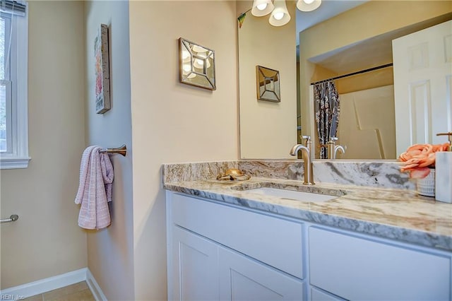 bathroom with vanity, baseboards, a shower with shower curtain, and a wealth of natural light