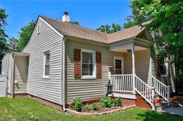 view of front of house featuring a porch, crawl space, a chimney, and roof with shingles
