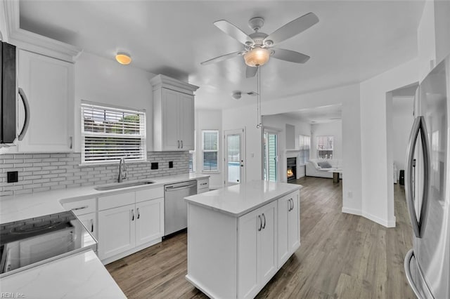 157 Pier Lndg, South Mills, NC 27976 - kitchen featuring a sink, a warm lit fireplace, a ceiling fan, appliances with stainless steel finishes, and backsplash