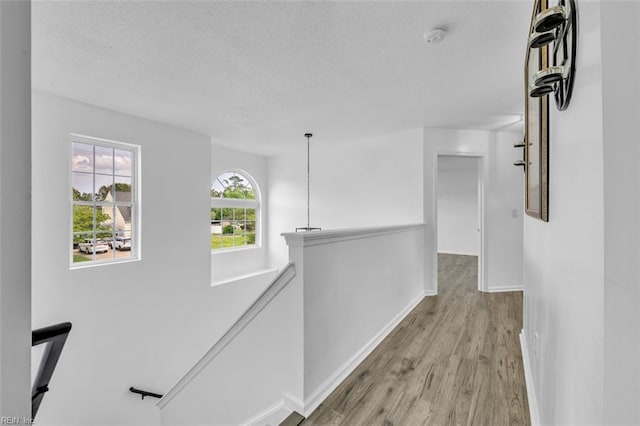 157 Pier Lndg, South Mills, NC 27976 - corridor featuring a textured ceiling, an upstairs landing, baseboards, and light wood finished floors
