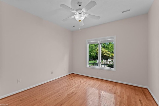 empty room featuring baseboards, visible vents, ceiling fan, and light wood-style floors