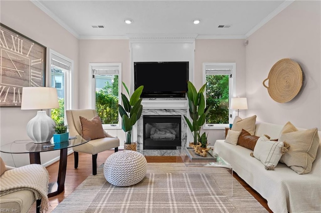 living area with visible vents, a wealth of natural light, and wood finished floors