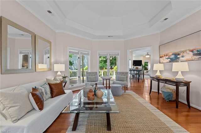 living area with ornamental molding, french doors, wood finished floors, and visible vents