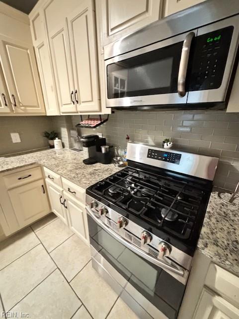 639 Mt Vernon Ave, Portsmouth, VA 23707 - kitchen with light stone counters, decorative backsplash, light tile patterned flooring, and stainless steel appliances