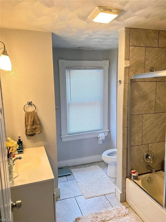 639 Mt Vernon Ave, Portsmouth, VA 23707 - bathroom with vanity, shower / bathtub combination, toilet, tile patterned floors, and baseboards