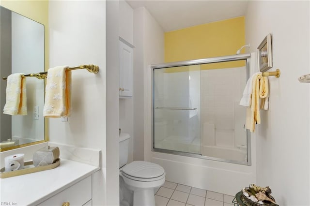 bathroom with toilet, bath / shower combo with glass door, tile patterned flooring, and vanity