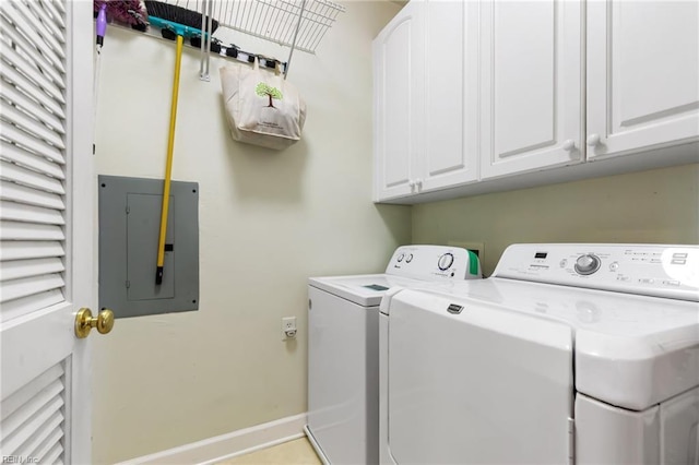 washroom featuring cabinet space, baseboards, washing machine and dryer, and electric panel