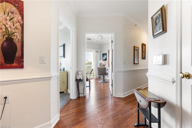 hallway with crown molding, baseboards, and wood finished floors