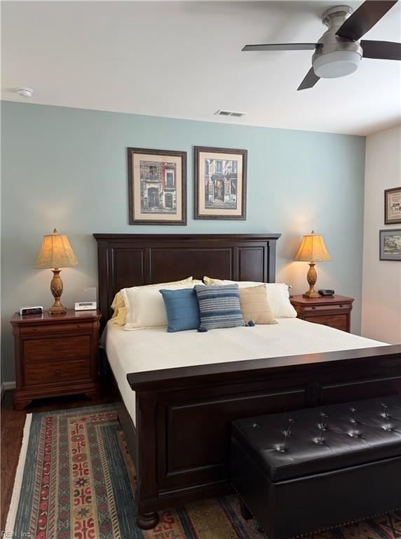 bedroom with dark wood-style flooring, a ceiling fan, and visible vents
