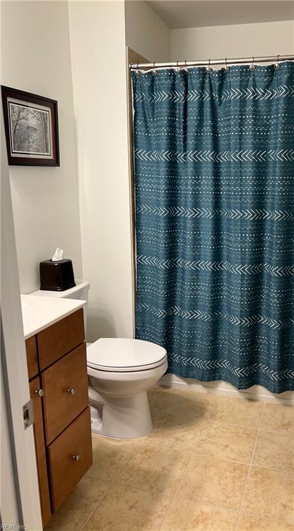 bathroom featuring toilet, tile patterned floors, a shower with shower curtain, and vanity