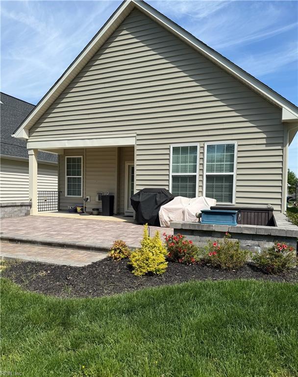 rear view of house with a lawn and a patio