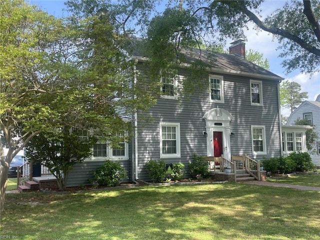 colonial house with a front lawn and a chimney