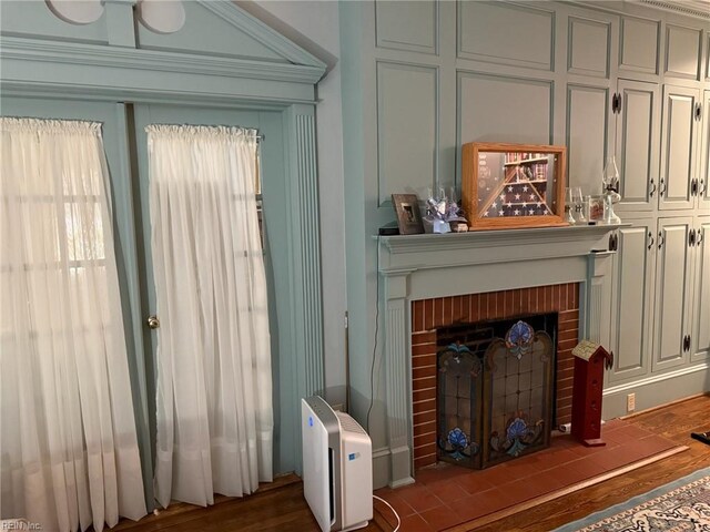 living area with a brick fireplace and wood finished floors