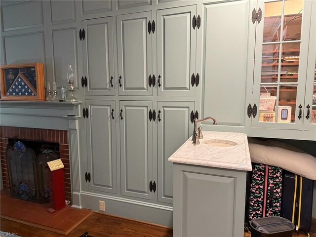 interior space featuring a sink, a fireplace, and wood finished floors