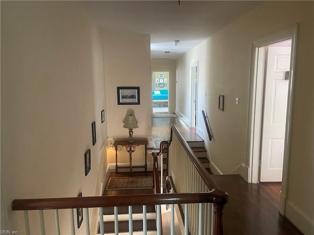 corridor with baseboards and wood finished floors