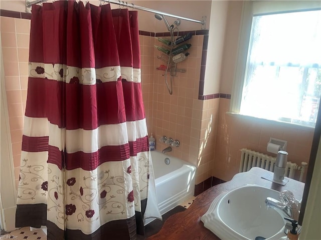 bathroom with a sink, radiator heating unit, and shower / bathtub combination with curtain