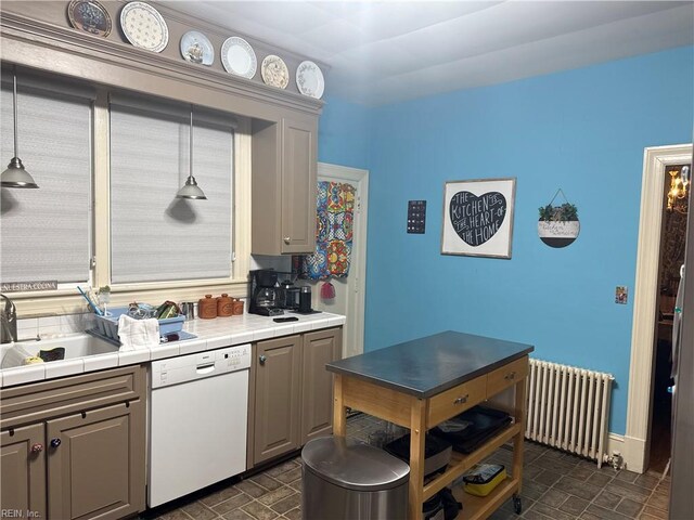 kitchen with a sink, dishwasher, tile counters, radiator heating unit, and gray cabinetry