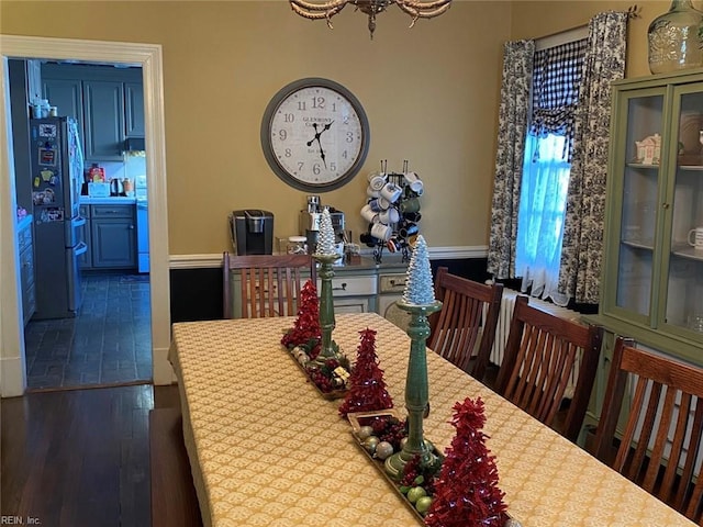 dining area with wood finished floors and a chandelier