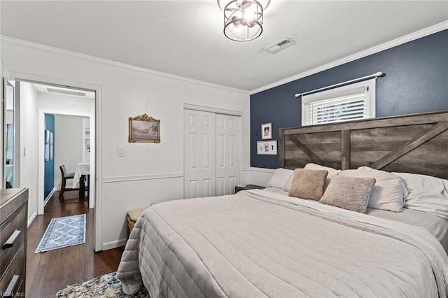 bedroom with visible vents, dark wood-style flooring, crown molding, and a closet