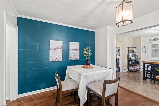 dining room featuring baseboards, ornamental molding, and wood finished floors