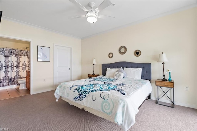 carpeted bedroom with connected bathroom, baseboards, ornamental molding, and ceiling fan