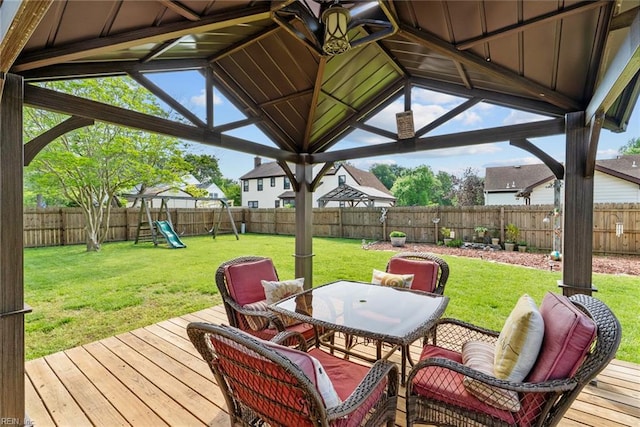 wooden deck featuring a lawn, outdoor dining area, and a fenced backyard