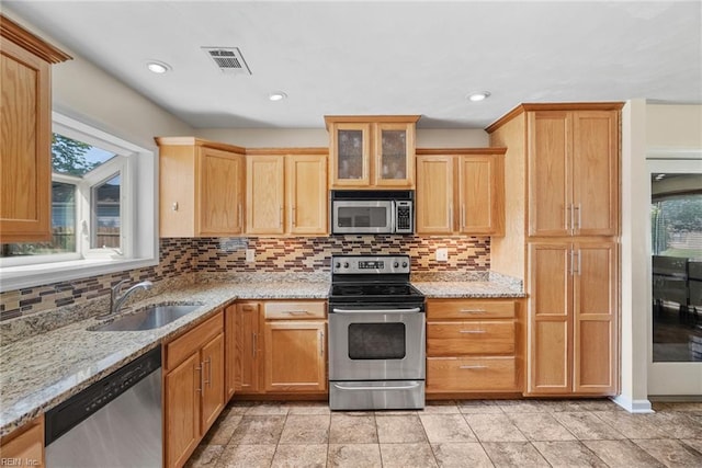kitchen with visible vents, a sink, appliances with stainless steel finishes, and backsplash