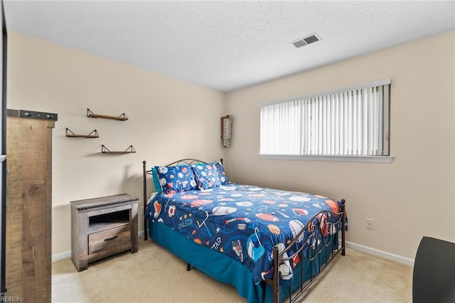 carpeted bedroom featuring a textured ceiling, baseboards, and visible vents
