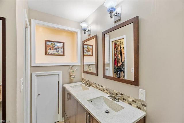 bathroom with double vanity, a sink, and tasteful backsplash