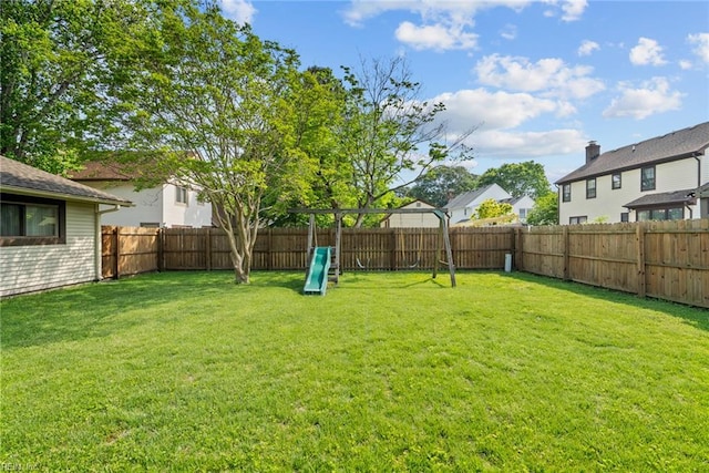 view of yard with a residential view, a fenced backyard, and a playground