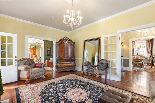 interior space featuring crown molding, baseboards, wood finished floors, and a notable chandelier