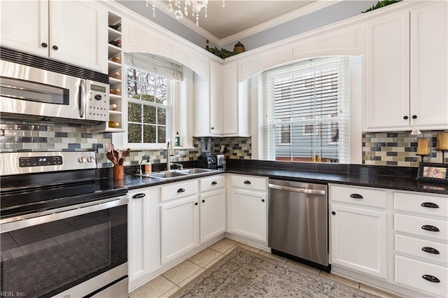 kitchen featuring a sink, appliances with stainless steel finishes, backsplash, and ornamental molding