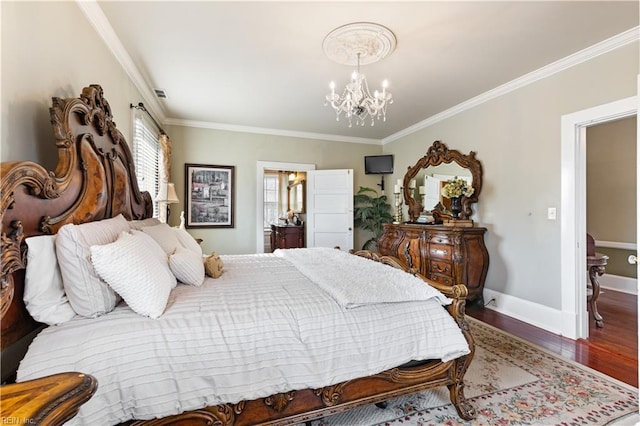 bedroom with crown molding, wood finished floors, baseboards, ensuite bathroom, and a chandelier
