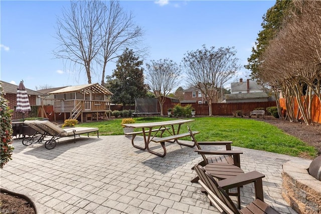 view of home's community with a lawn, a fenced backyard, a trampoline, and a patio area