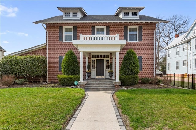 colonial house featuring brick siding, fence, and a front lawn